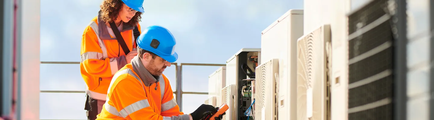 two maintenance workers analyzing an HVAC