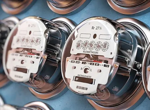 Close-up of multiple analog electricity meters mounted on a wall, measuring power usage
