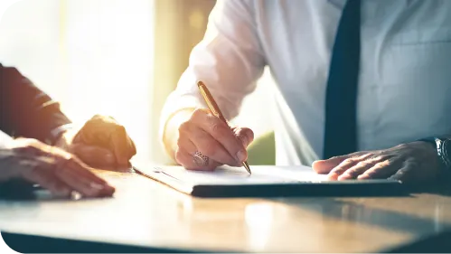 two people signing a document