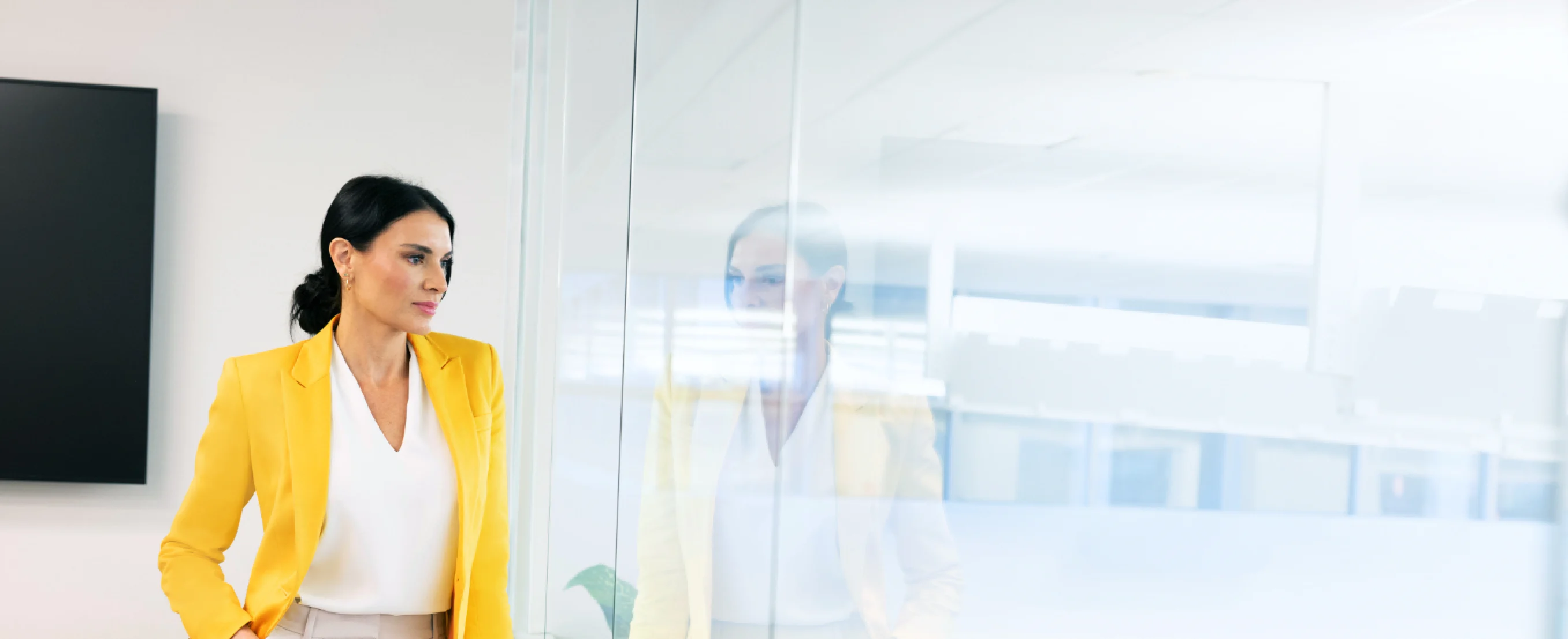 Woman at an office looking over a glass wall